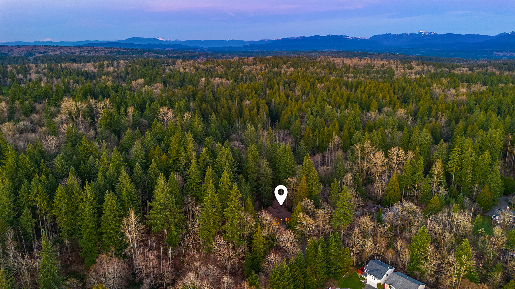 Aerial view of the residence set within 2.53 wooded acres on the Sammamish plateau