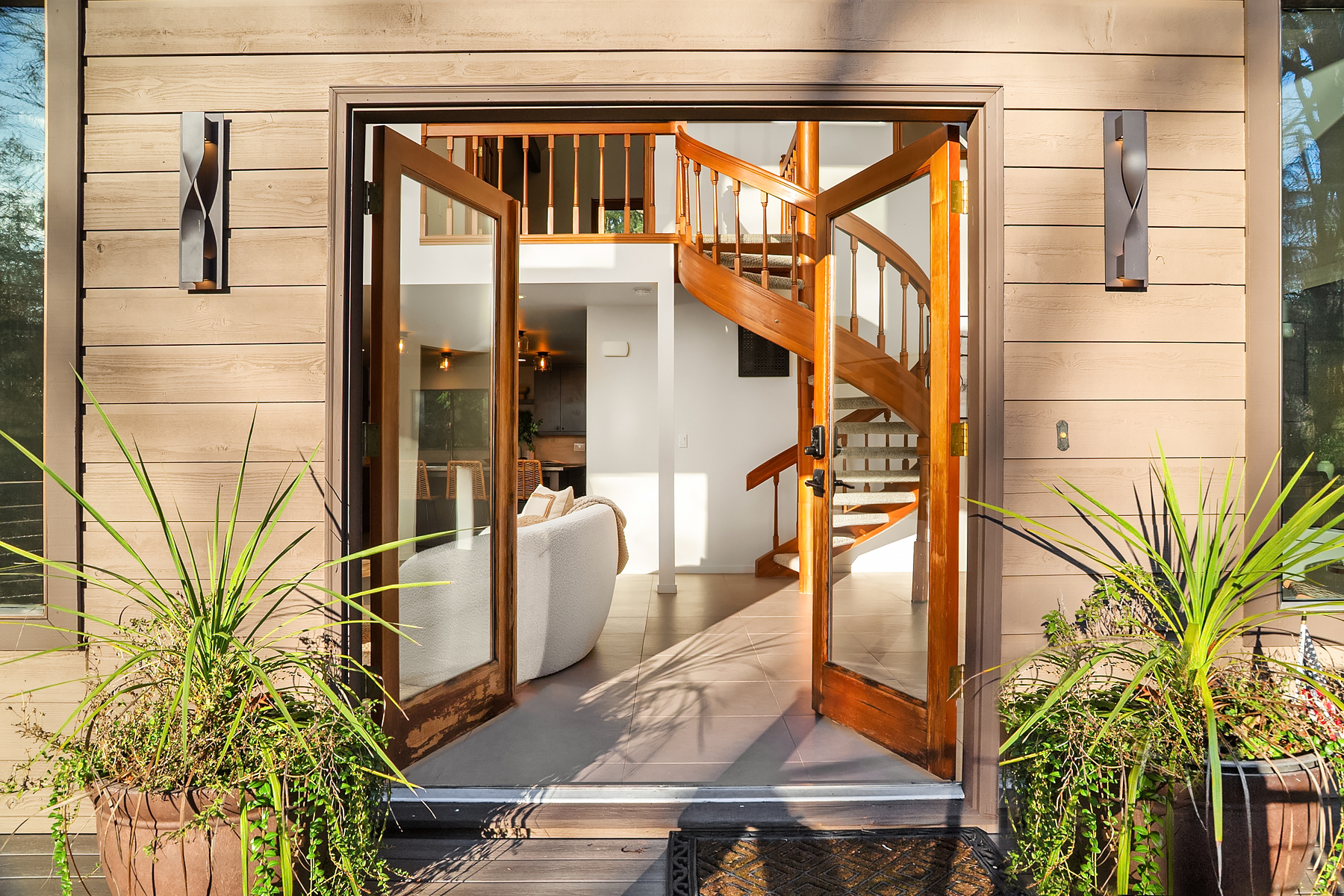 Open double doors revealing the honey-wood spiral staircase inside